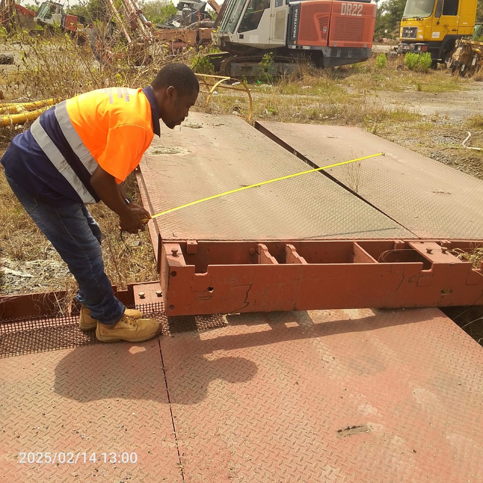 Technician measuring a weighbridge deck on site