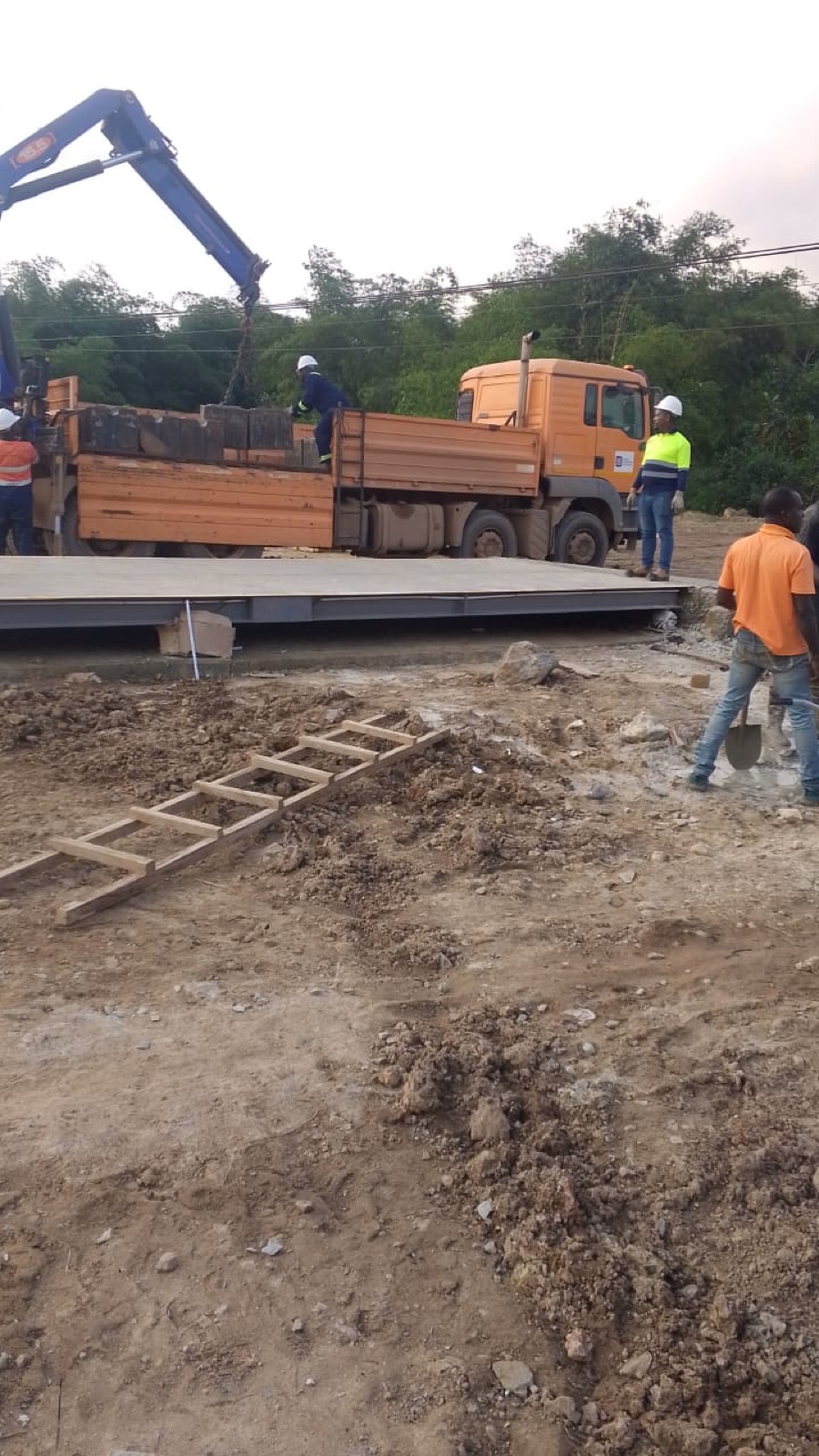Two workers measuring a weighbridge foundation layout