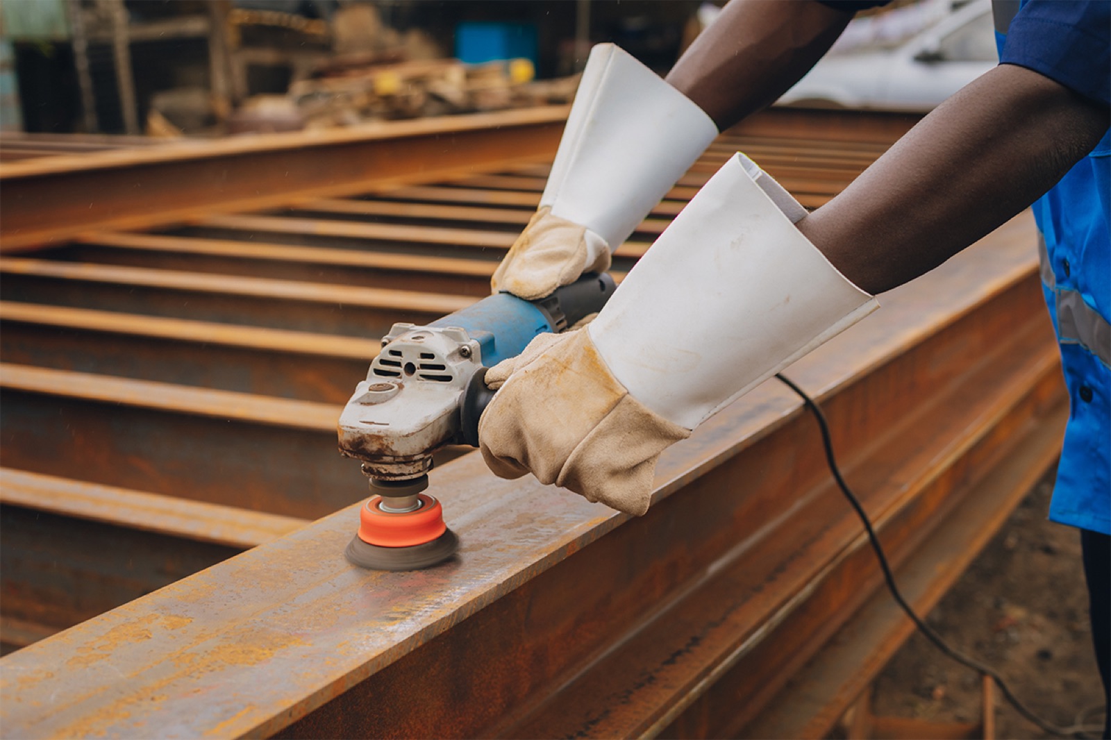 EMESS technician grinding a steel beam